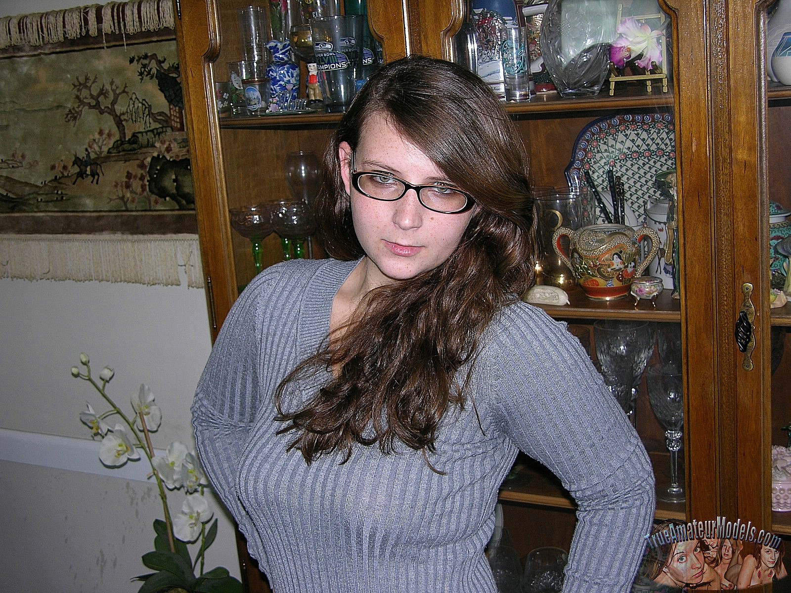Nerdy amateur teen Skyye wearing glasses gets undressed and spreads her pussy image